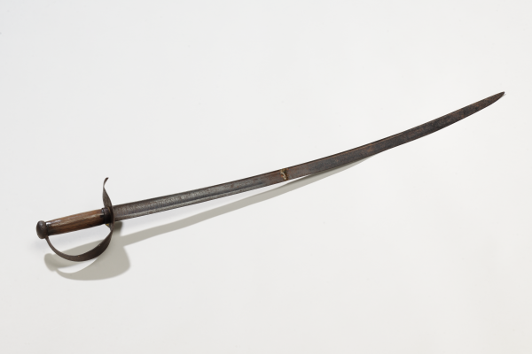Historic curved saber with a simple wooden grip and iron knuckle guard.