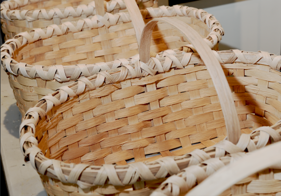 A close-up view of several handwoven baskets made from natural wooden strips.